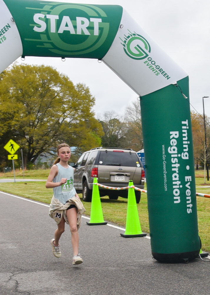 A young runner crosses the finish line