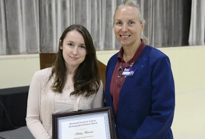Massage therapy grad poses with diploma