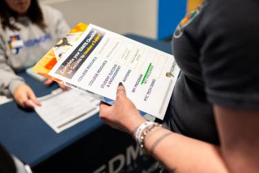 Student holding an orientation checklist document