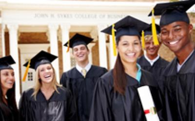 graduates in caps and gowns smiling