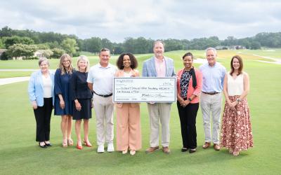 Group on a golf course collecting a check