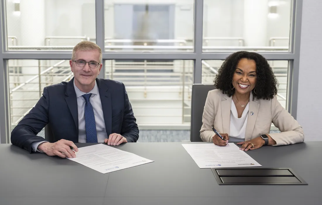 Two people signing documents