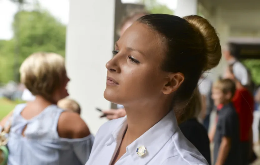 female nursing standing with people in the background