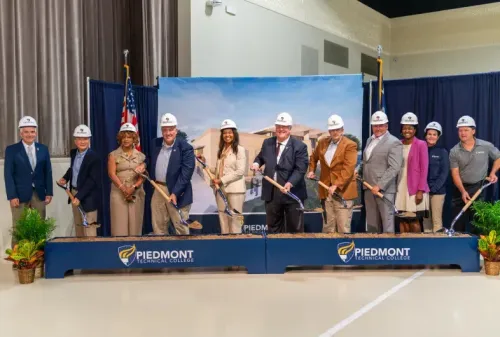 Administration posing in hard hats with shovels