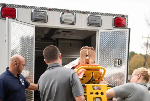 EMS workers loading gurney onto ambulance