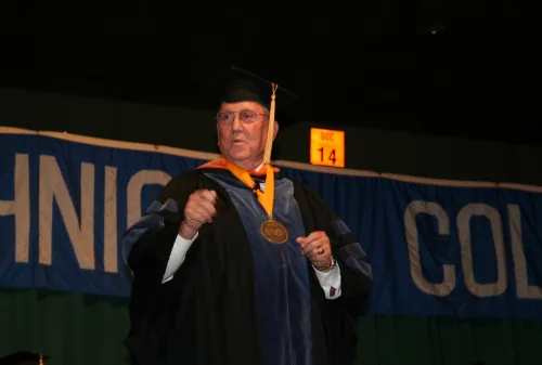 Man in academic regalia speaking