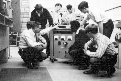 Men gathered around a machine