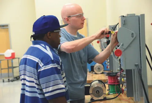 Man teaching student electrical process